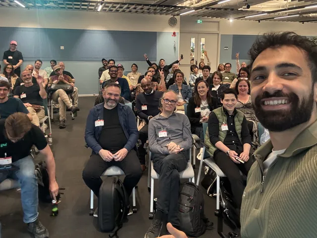 Mo taking a selfie in front of a big, smiling audience at the AWS and Vorker demo.